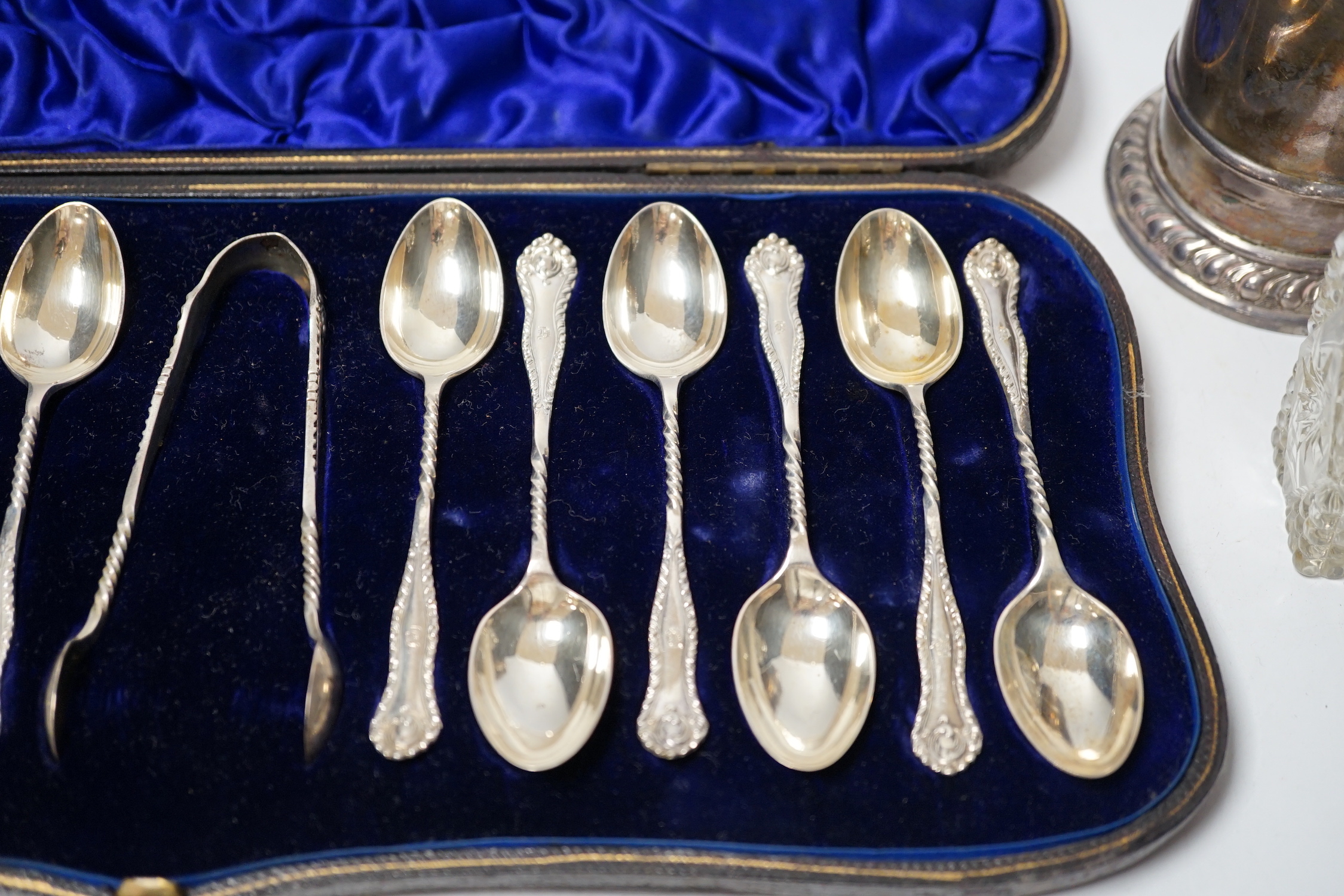 A cased set of twelve late Victorian silver teaspoons with tongs, William Hutton & Sons, London, 1898, a late Victorian silver lighthouse sugar caster, London, 1889, five assorted silver napkin rings and a silver mounted